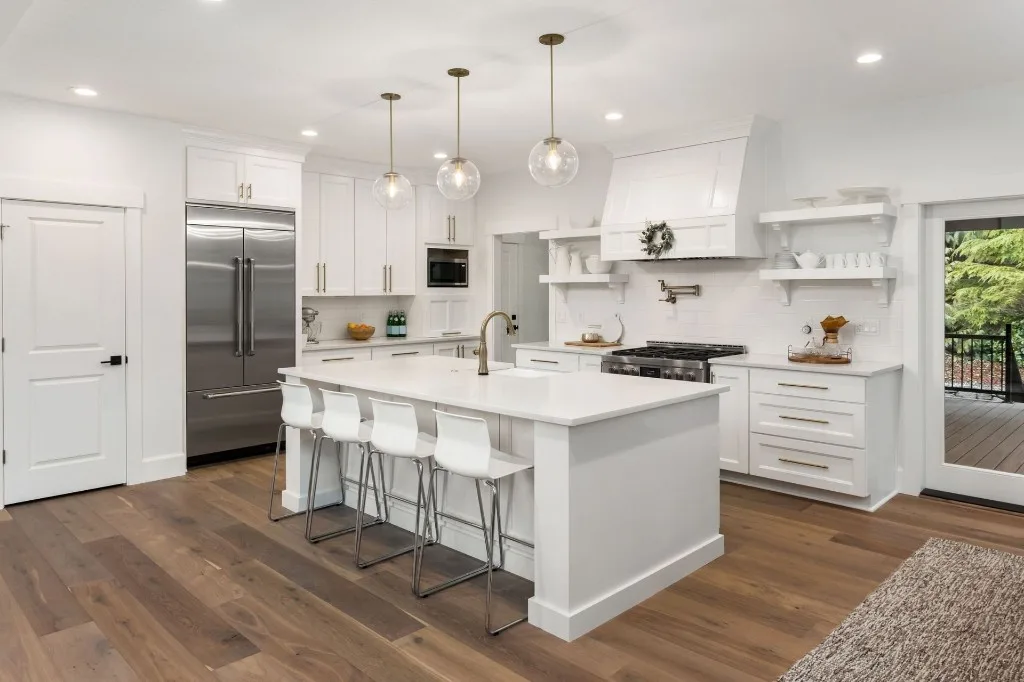 Bright white kitchen with island seating and stainless appliances
