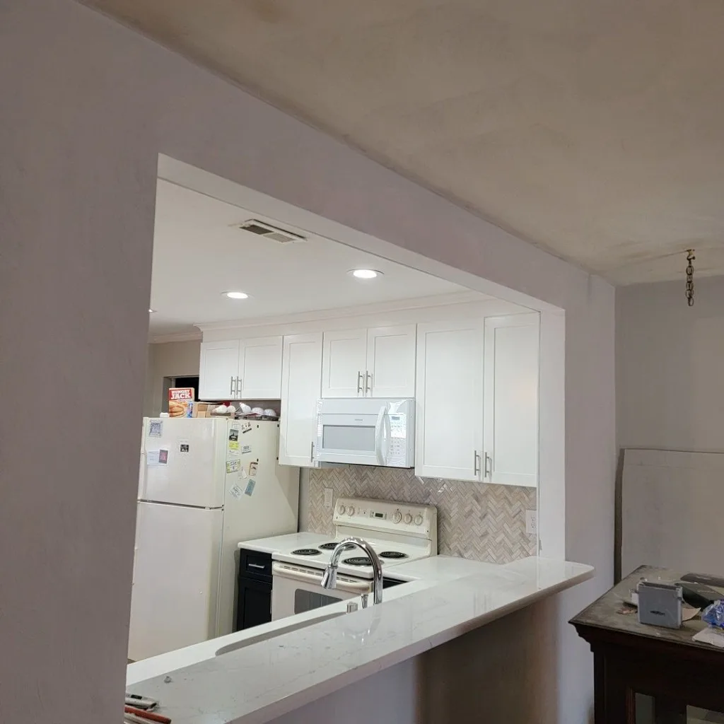 White kitchen with peninsula sink and stainless appliances