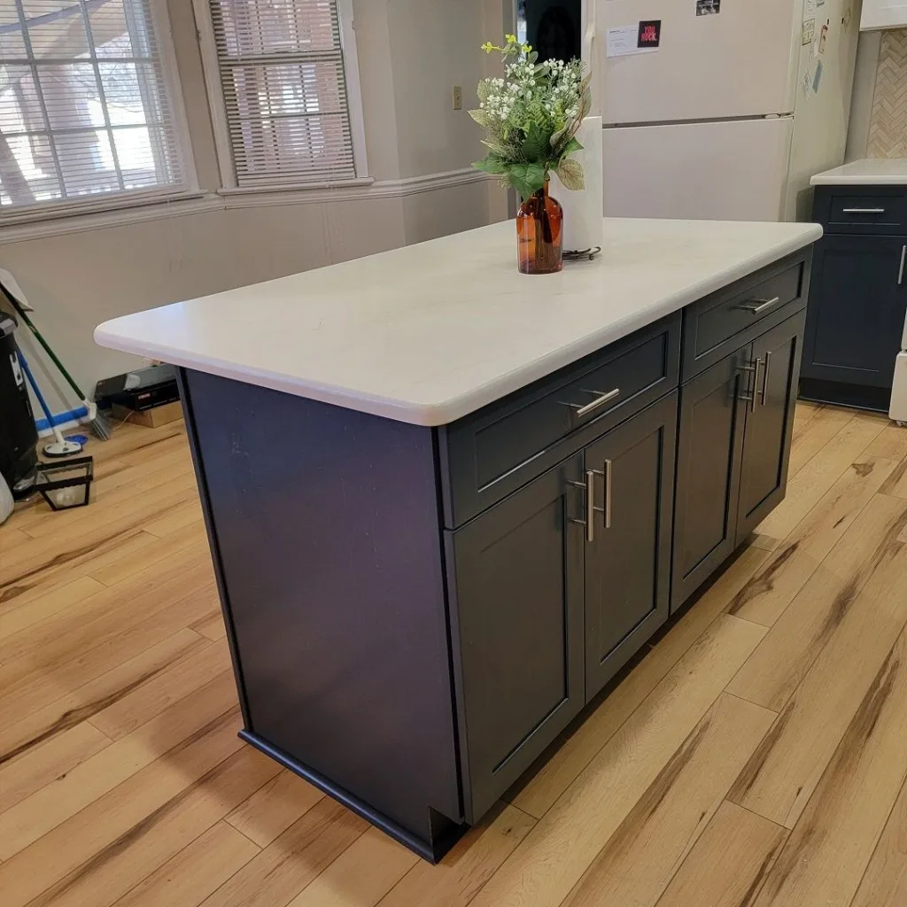 Navy island kitchen with fridge wall and tiled backsplash