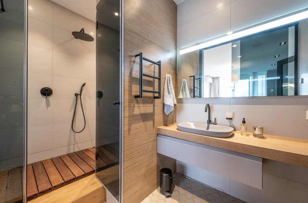 Bright white bath with open shower and black floor pattern
