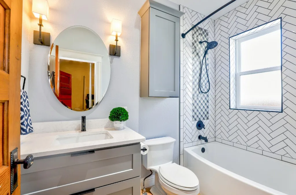White bathroom with patterned tile and glass shower enclosure