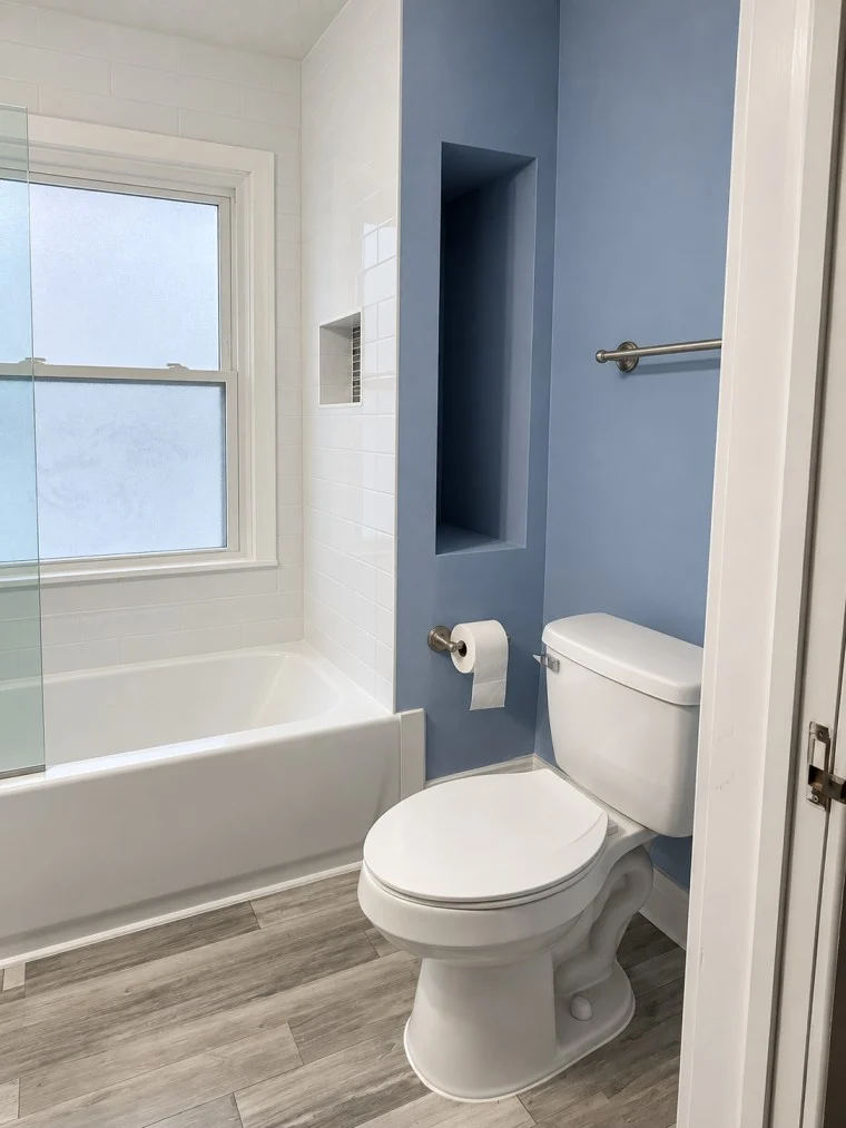 Modern bathroom remodel with blue wall and bathtub