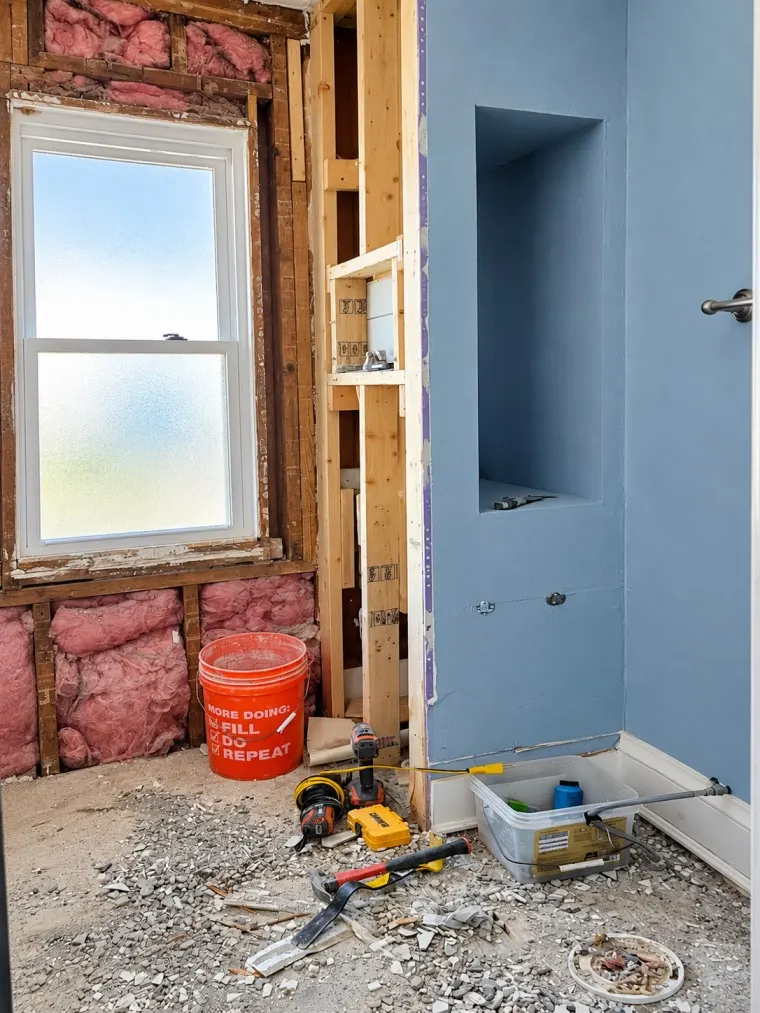 Bathroom renovation in progress with exposed framing