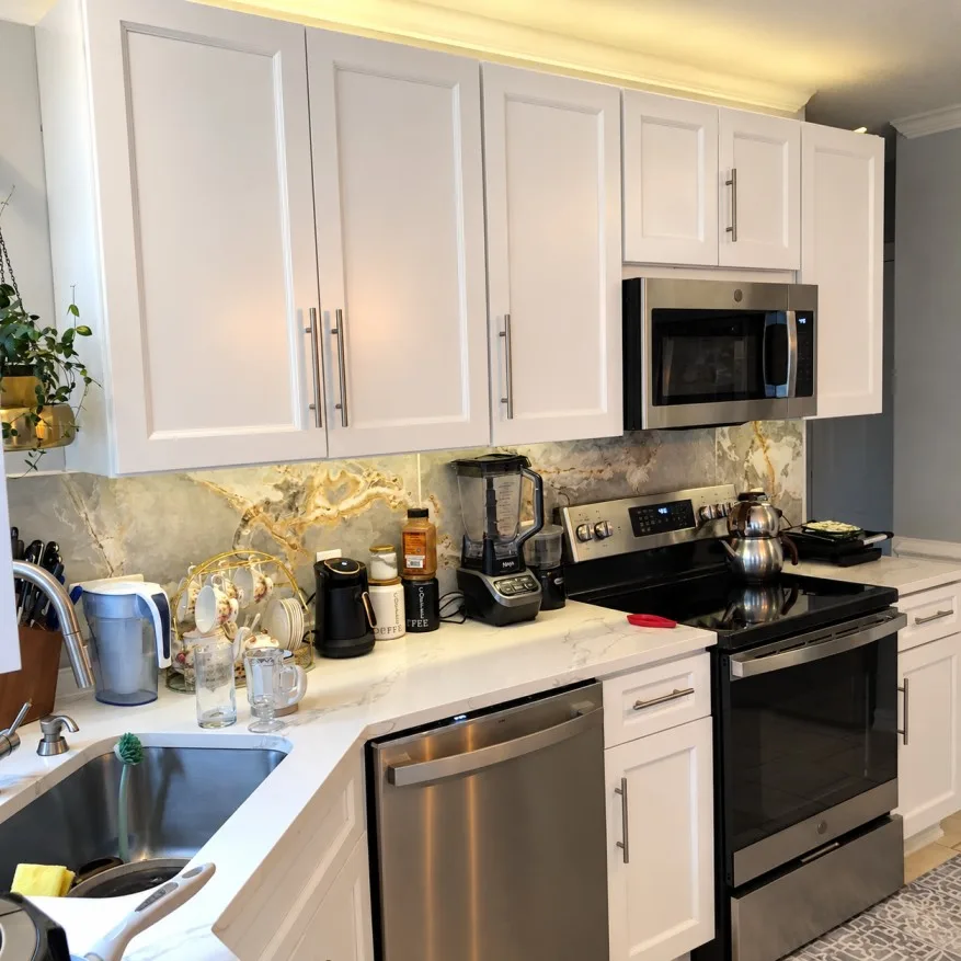 Kitchen corner with sink, cabinets, and appliances