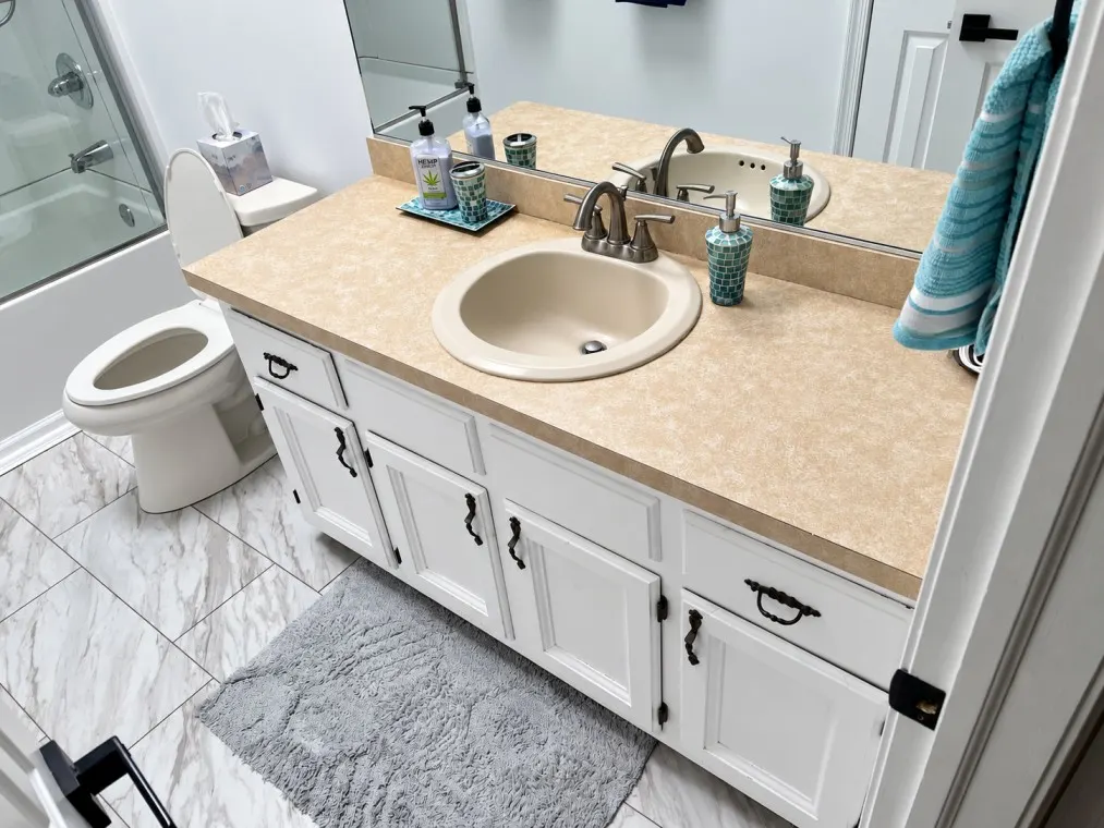 Bathroom vanity renovation before view with old cabinets and countertop